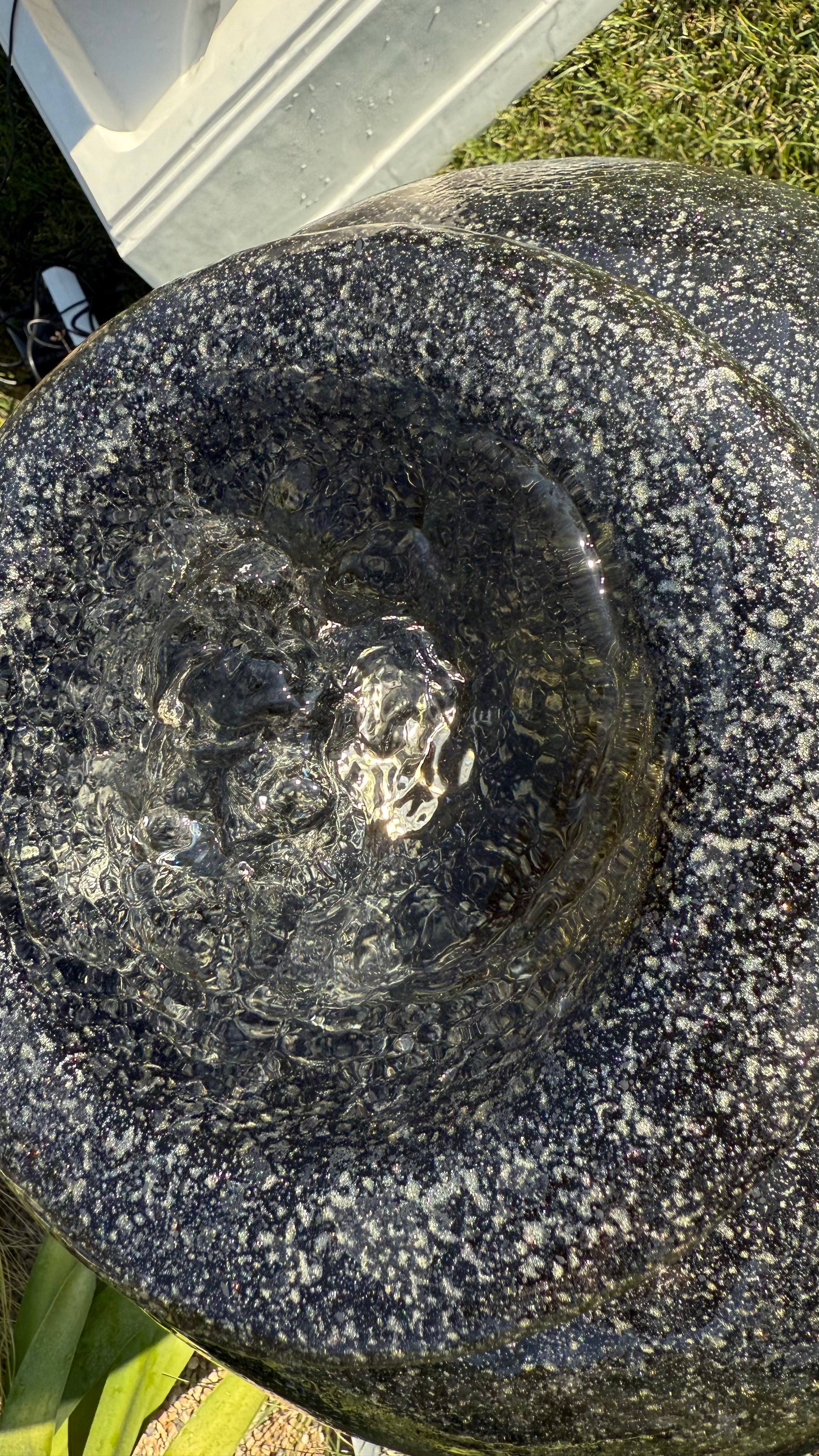 Vue rapprochée du sommet du grand vase de l'Ensemble Socle Noir Moderne, montrant l'eau en mouvement dans la fontaine.